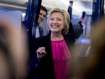 Democratic presidential candidate Hillary Clinton, accompanied by Traveling Press Secretary Nick Merrill, left, smiles as she speaks to members of the media as her campaign plane prepares to take off at Westchester County Airport in Westchester, N.Y., Tuesday, Sept. 6, 2016, to head to Tampa for a rally in Tampa. …