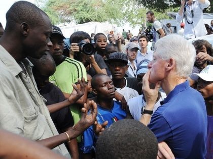 Former US president and UN Special Envoy for Haiti Bill Clinton (R) listens to local resid