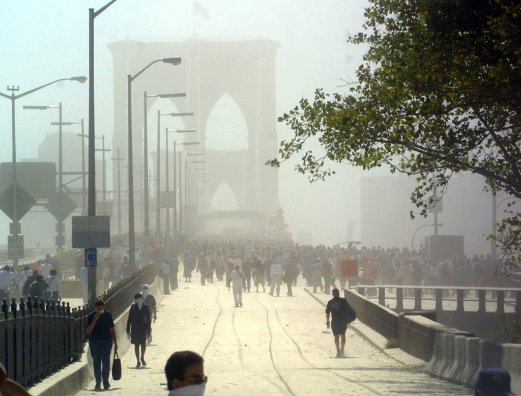Pedestrians can be seen crossing the Brooklyn Bridge as they flee Manhattan after the collapse of the first World Trade Center Tower 11 September, 2001 in New York. AFP PHOTO Doug KANTER (Photo credit should read DOUG KANTER/AFP/Getty Images)