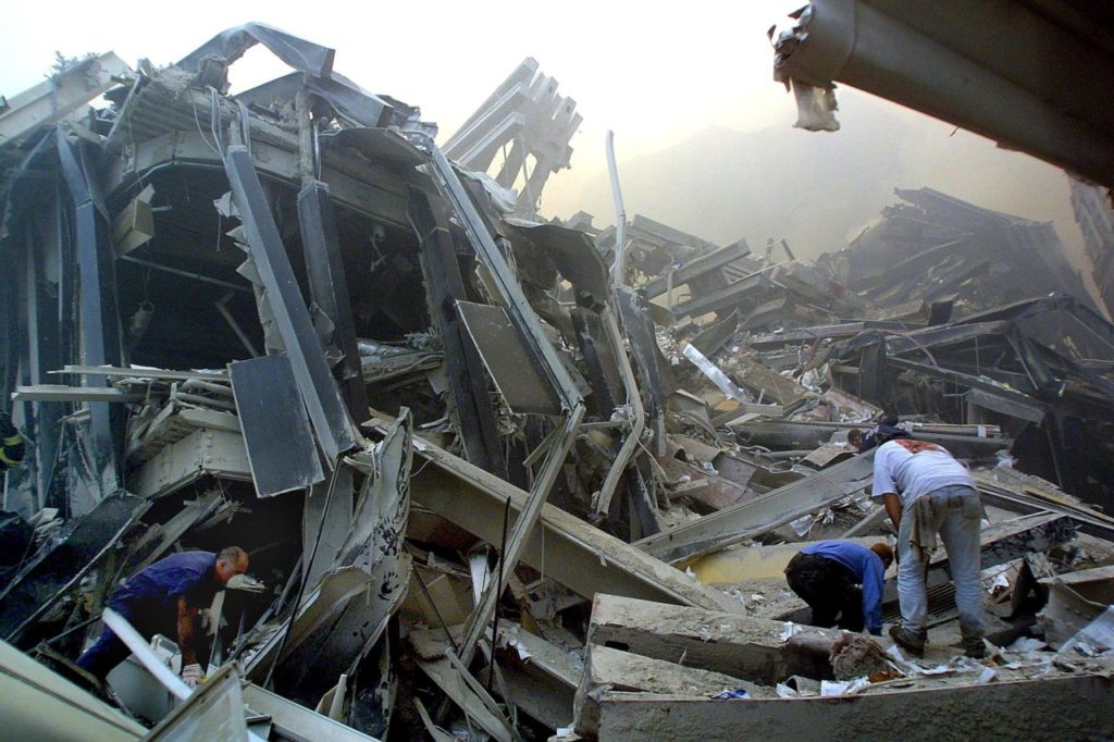 Rescue workers make their way through the rubble of the World Trade Center 11 September 2001 in New York after two hijacked planes flew into the landmark skyscrapers. AFP PHOTO/Doug KANTER (Photo credit should read DOUG KANTER/AFP/Getty Images)