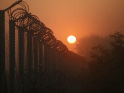 The sun rises over the nearly completed border fence at the Hungarian border with Serbia o