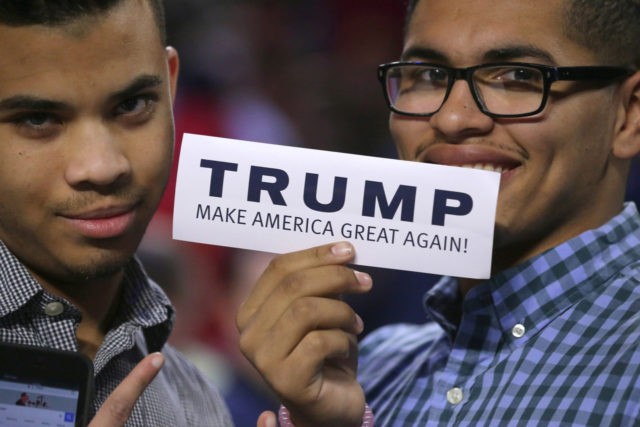 LYNCHBURG, VA - JANUARY 18: Two young men hold up a bumper sticker which says 'Trump