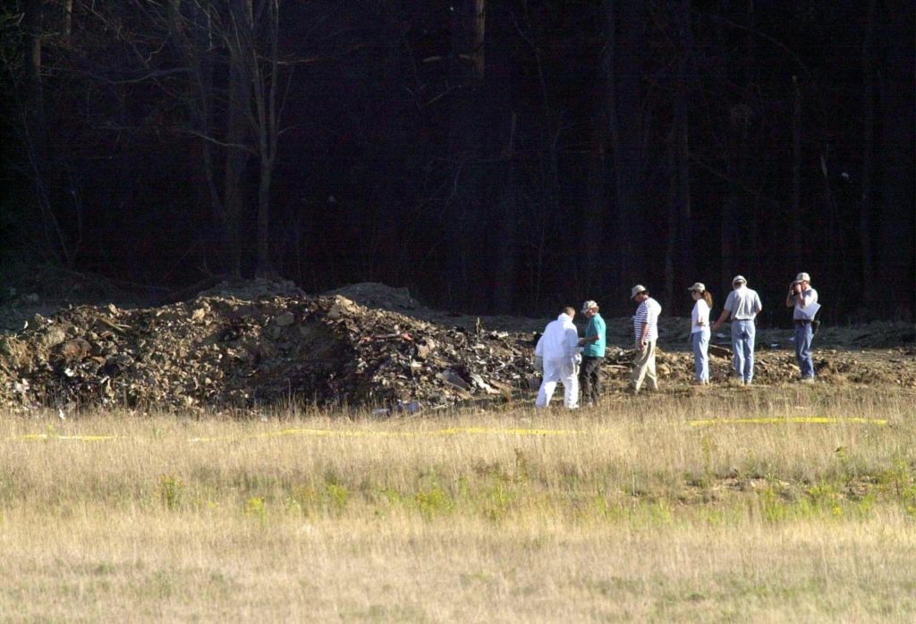 SHANKSVILLE, UNITED STATES: 7/10 US-ATTACKS-2ND YEAR ANNIVERSARY Officials examine the crater 11 Septemner 2001 at the crash site of United Airlines Flight 93 in Shanksville, Pennsylvania. The plane from Newark, New Jersey, and bound for San Francisco, California, was hijacked and crashed in the field killing al on board. The all-out war on terrorism unleashed by Washington after the attacks marked a turning point in US-Arab relations and nowhere more so than in once top ally Saudi Arabia. With 15 of the 19 suicide hijackers carrying Saudi nationality and mastermind Osama bin Laden being the scion of a leading Saudi family, the desert kingdom and world oil kingpin, suddenly found itself on the frontline of the war on terror prosecuted by US President George W. Bush. AFP PHOTO/David MAXWELL (Photo credit should read DAVID MAXWELL/AFP/Getty Images)