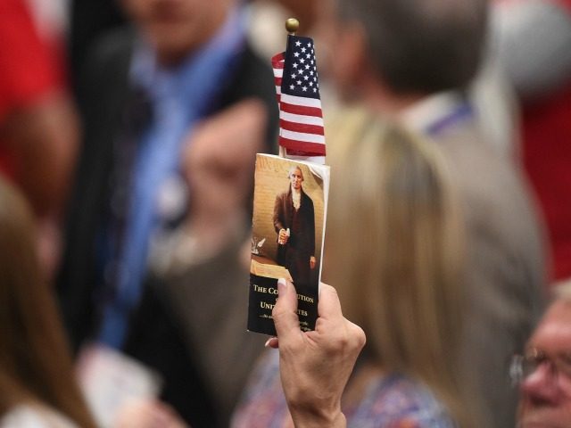 A delegate holds up a copy of the constitution at the Republican National Convention at th