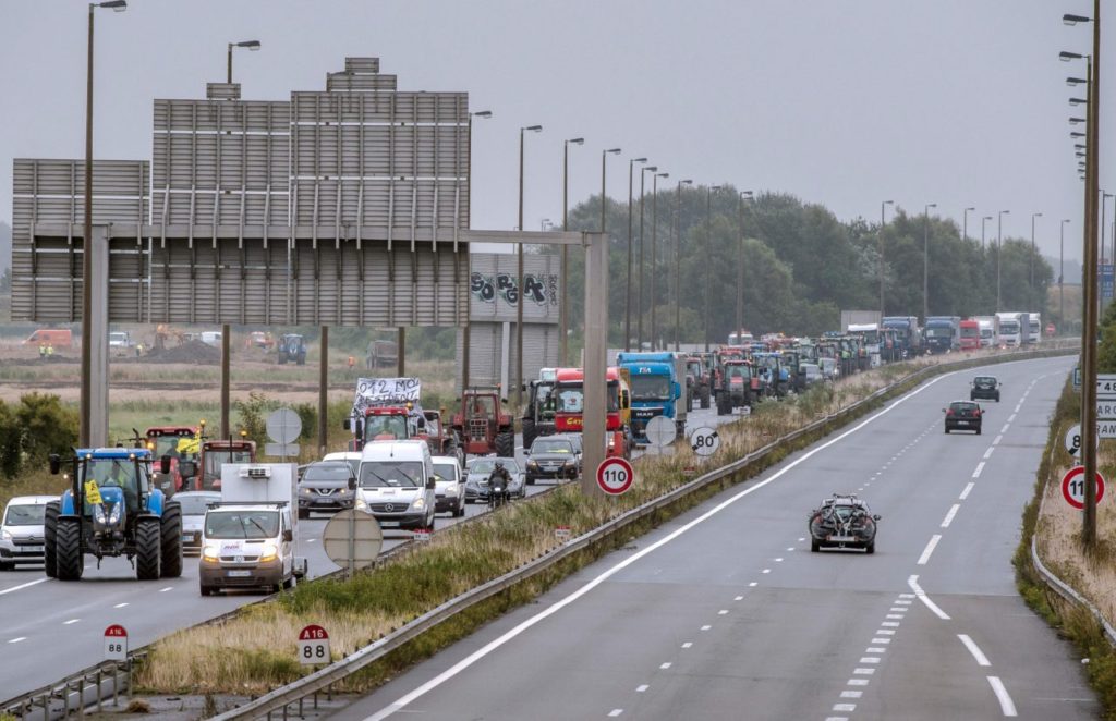 Truck drivers and farmers drive from Loon Plage to Calais, on September 5, 2016, during a joint "go-slow" protest on the A16 highway calling for the dismantling of the so-called "Jungle" migrant camp in the French northern port city of Calais. French farmers and truckers launched a joint operation on September 5, 2016 to block off main routes in and out of Calais to call for the closure of the sprawling "Jungle" migrant camp there. Around 70 trucks began a "go-slow" on the main A16 motorway -- the main artery for freight and passengers heading for Britain either via the Channel Tunnel or the Calais port. / AFP / PHILIPPE HUGUEN (Photo credit should read PHILIPPE HUGUEN/AFP/Getty Images)