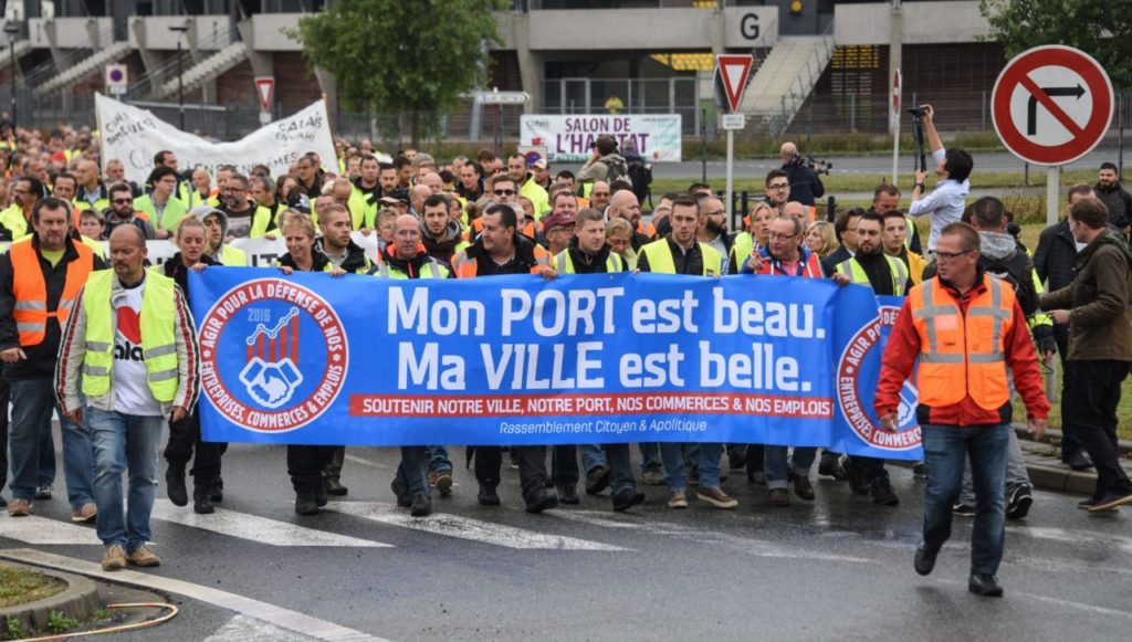 People hold a banner, reading "My harbour is beatiful, My city is beautiful", as they take part in a demonstration on September 5, 2016 in Calais, to call for the dismantling of the so-called "Jungle" migrant camp in the French northern port city of Calais. The Jungle, a squalid camp of makeshift tents and shelters, is home to around 7,000 migrants but charities say the number might be as high as 10,000 after an influx this summer. / AFP / DENIS CHARLET (Photo credit should read DENIS CHARLET/AFP/Getty Images)