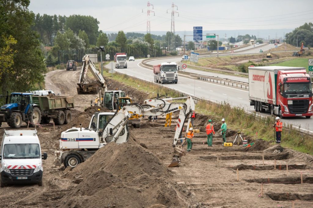 Workers dig foundations of a wall near Calais migrant 'Jungle' camp along the road leading to the harbour of Calais, northern France on September 20, 2016 to stop migrants from jumping on lorries heading to Britain. The squalid migrant camp known as the "Jungle" in France's northern port of Calais has become home to nearly 1,000 more people since August, bringing the total to more than 10,000, two charities working there said on September 19. / AFP / PHILIPPE HUGUEN (Photo credit should read PHILIPPE HUGUEN/AFP/Getty Images)