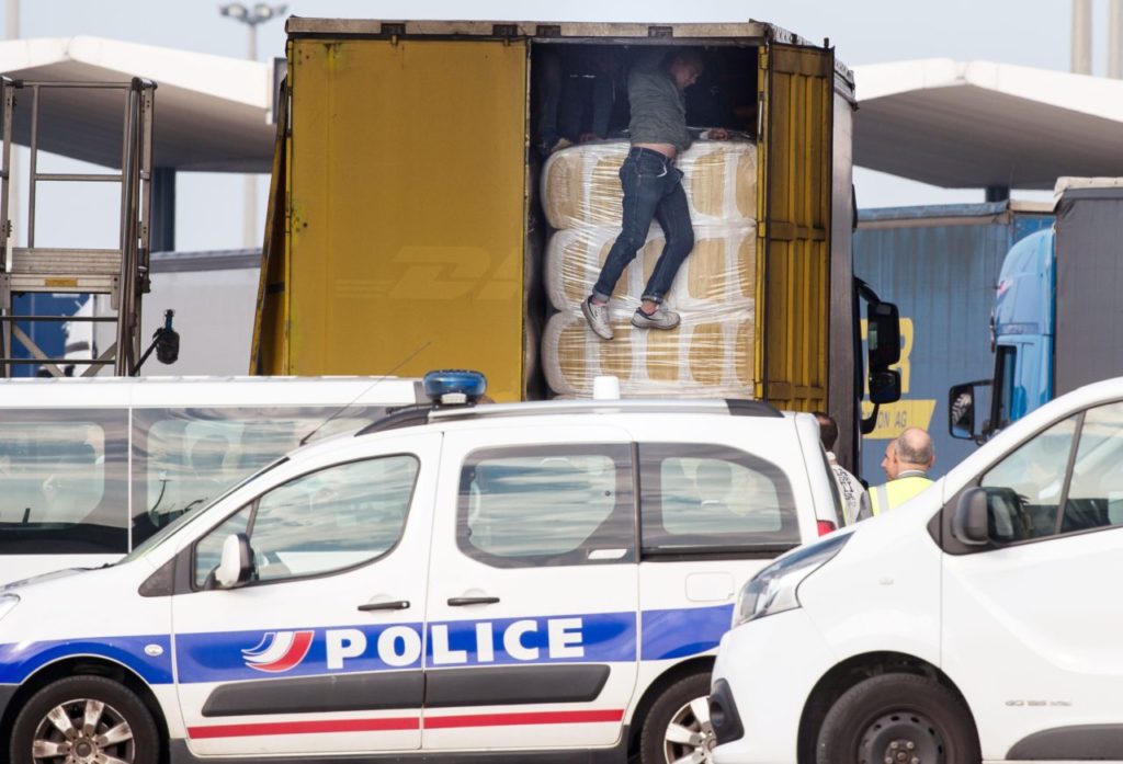 A migrant gets out of a lorry heading to Britain, after being spotted by police in Calais, northern France on September 21, 2016. The squalid migrant camp known as the "Jungle" in France's northern port of Calais has become home to nearly 1,000 more people since August, bringing the total to more than 10,000, two charities working there said on September 19. / AFP / PHILIPPE HUGUEN (Photo credit should read PHILIPPE HUGUEN/AFP/Getty Images)
