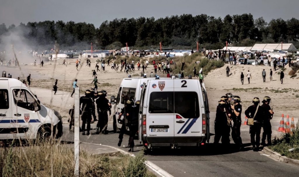Riot police disperse migrants trying to get into trucks heading to Great Britain, on September 21, 2016 in Calais. / AFP / PHILIPPE HUGUEN (Photo credit should read PHILIPPE HUGUEN/AFP/Getty Images)