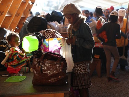 TIJUANA, MEXICO - SEPTEMBER 24: Haitian refugees look over donated items at an immigrant