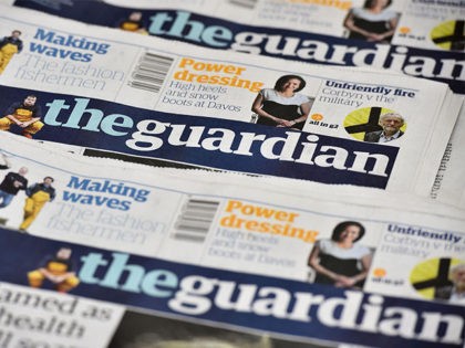 An arrangment of Guardian newspapers is photographed in an office in London on January 26, 2016. The Guardian newspaper is to cut running costs by 20 percent over three years and may begin charging for some online content following a 25-percent plunge in print advertising, British media reported Tuesday. / …