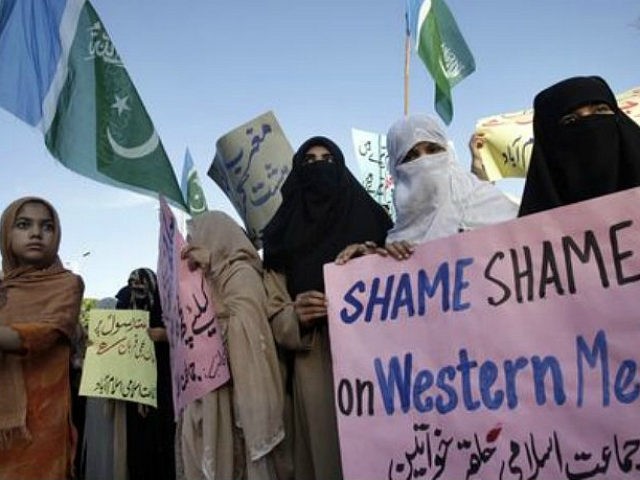 A girl holds a flag of Islamic political party Jamaat-e-Islami while taking part in a prot