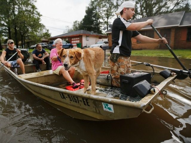 RESERVE, LA - AUGUST 30: Jewel Rico and her dog Chico are rescued from flood waters from H