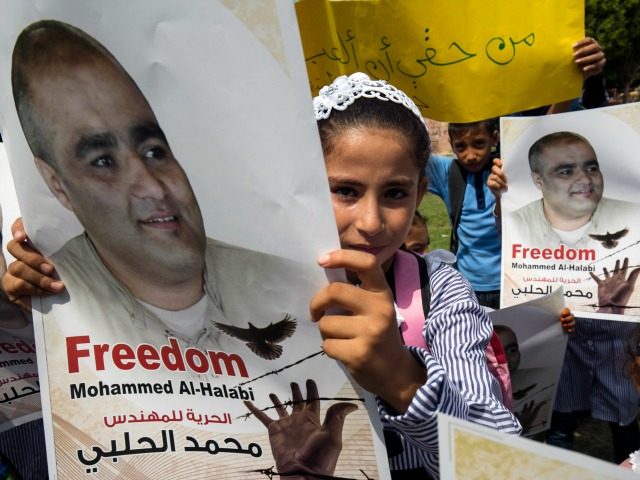 Palestinian children hold posters of Mohammed Halabi (L), the Gaza director of World Visio