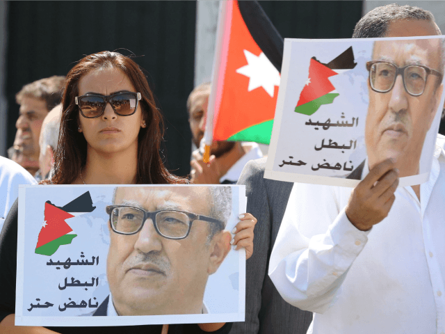Protesters hold portraits of prominent Jordanian writer Nahed Hattar, who was shot dead th