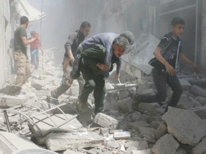 Syrians evacuate an injured man amid the rubble of destroyed buildings following a reported air strike on the rebel-held neighbourhood of Al-Qatarji, in the northern Syrian city of Aleppo, on April 29, 2016. Fresh bombardment shook Syria's second city Aleppo, severely damaging a local clinic as outrage grows over an …