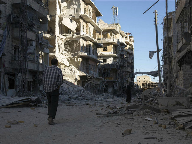 SYRIA, ALEPPO : TOPSHOT - A Syrian man walks past a heavily damaged building following air