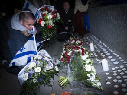 People light candles and place Israeli flags on February 16, 2015 in front the Danish Embassy in Brussels for the the victims of weekend attacks on a cultural center and a synagogue in Copenhagen that left two people dead including a 37-year-old Jewish man as well as a 55-year-old film-maker …