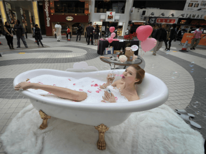 A model sits in a bathtub to promote a shopping mall in Hong Kong on February 5, 2009. A government spokesman said visitors to Hong Kong and solid spending by residents had helped boost retail figures, but warned it remained a tough environment. AFP PHOTO/MIKE CLARKE (Photo credit should read …
