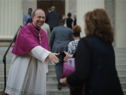 BALTIMORE, MD - APRIL 25: Catholic Archbishop of Baltimore William Lori (L) welcomes people to the Basilica of the National Shrine of the Assumption of the Blessed Virgin Mary for an interfaith prayer service for peace marking the first anniversary of unrest following the death of Freddie Gray April 25, …