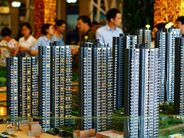 --FILE--Chinese homebuyers look at housing models at the sales center of a residential pro