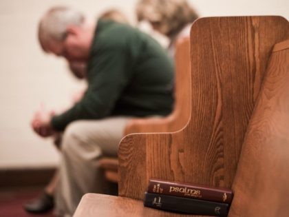 People bow their heads in prayer during a Sunday evening service at Grace Orthodox Presbyterian Church in Lynchburg, Virginia, on January 17, 2016. The young evangelical Christians at Liberty University in Virginia are facing a dilemma this election season: whether to follow in the footsteps of their parents and back …