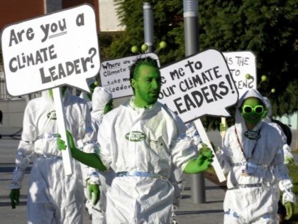Activists of the environmental group Avaaz perform wearing costumes representing an alien delegation mingled with UN delegates holding placards reading 'Where is your climate leader ? Take me your climate leader' during the Barcelona Climate Change Talks on November 6, 2009 in Barcelona. Some 180 countries hold the last day …
