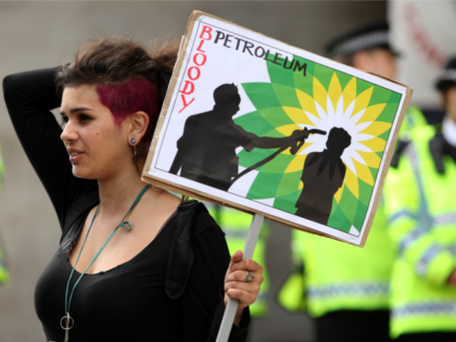LONDON, ENGLAND - SEPTEMBER 01: A climate change protester holds an anti-BP banner in fron