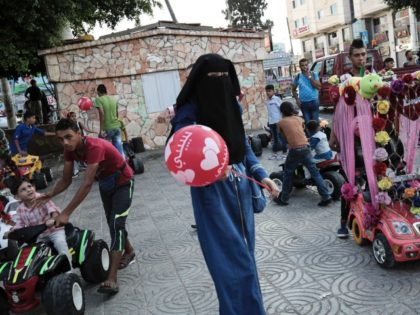 A Palestinian woman holds a balloon in the street in Gaza City as Muslims celebrate the second day of Eid al-Adha (Festival of Sacrifice) holiday on September 13, 2016. / AFP / SAID KHATIB (Photo credit should read SAID KHATIB/AFP/Getty Images)