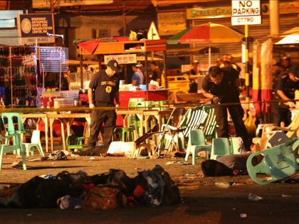 Philippine police officers look at dead victims after an explosion at a night market that