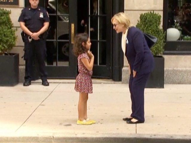 U.S. Democratic presidential nominee Hillary Clinton greets a girl on the sidewalk after l