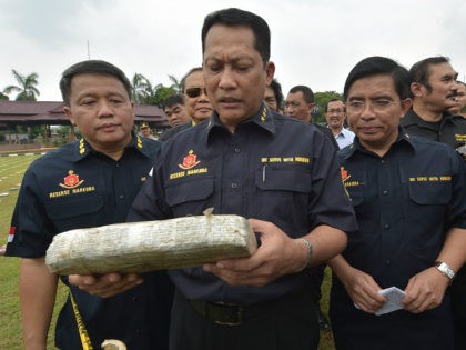 INDONESIA, JAKARTA : Budi Waseso (C), Indonesian chief of criminal investigation division, holds a seized marijuana block at the national police headquarters in Jakarta on May 11, 2015. Indonesian police revealed 2.1 tons of marijuana packages as evidence from recent raids. AFP PHOTO / ADEK BERRY2015.