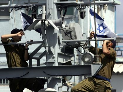Israeli sailors raise the national and navy flags as they ready to go out on patrol on the 'Devora' gunship from their base in the portal city of Haifa, 26 March 2006. The gunship is going out on a patrol along the Israeli Mediterranean coast. AFP PHOTO/MENAHEM KAHANA (Photo credit …