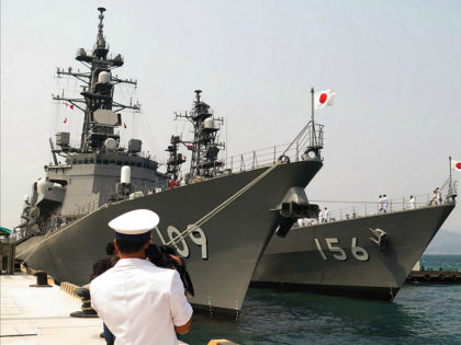 This picture taken on April 12, 2016 shows a Vietnamese Navy officer (foreground) filming two Japanese Navy's guided-missile destroyers anchored at Cam Ranh Bay in central Vietnam. The two Japanese Self-Defence Force guided-missile destroyers Ariake and Setogiri with 500 sailors aboard are paying a four-day port call at Cam Ranh …