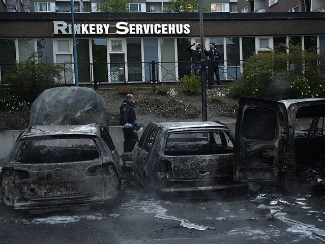 A police officers passes the scene of cars gutted by fire in the Stockholm suburb of Rinkeby after youths rioted in several different suburbs around Stockholm, Sweden for a fourth consecutive night on May 23, 2013. In the suburb of Husby, where the riots began on Sunday in response to the fatal police shooting of a 69-year-old machete-wielding man, 80 percent of residents are immigrants and the unrest has highlighted Sweden's failure to integrate swathes of its immigrant population, but in this small, consensus-driven country, there was little agreement on how to solve the problem. AFP PHOTO / JONATHAN NACKSTRAND (Photo credit should read JONATHAN NACKSTRAND/AFP/Getty Images)