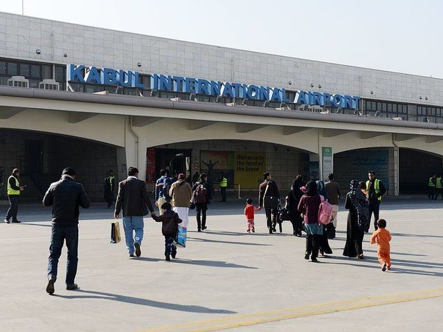 Passengers of a commercial airliner walk towards the main building of Kabul's Khwaja Rawash International airport in Kabul on December 26, 2013, after their disembarkation from an aircraft. The airport initially built in the 1960's has been upgraded in the last decade and it is surrounded by national and foreign …