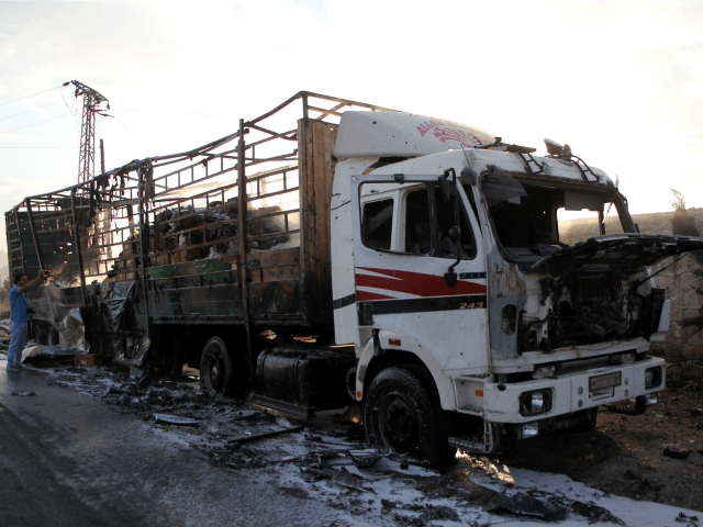 A damaged truck carrying aid is seen on the side of the road in the town of Orum al-Kubra