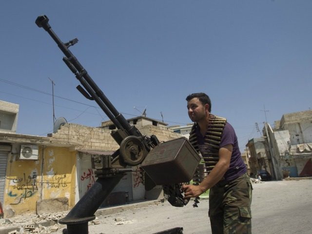A Syrian rebel fighter loads an anti-aircraft machinegun in the northern town of Atareb, 2
