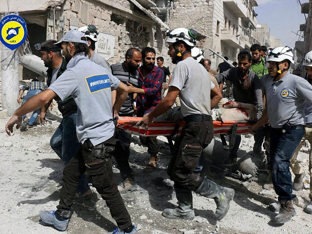 In this photo provided by the Syrian Civil Defense White Helmets, rescue workers work the