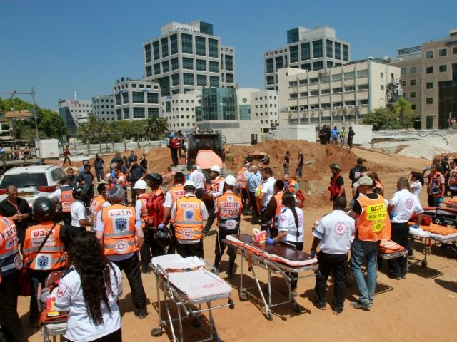 Israeli members of the Magen David Adom rescue service wait next to stretchers after an un