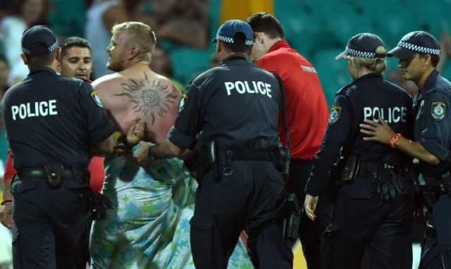 Policemen lead away a streaker during the fifth one-day international between Australia an