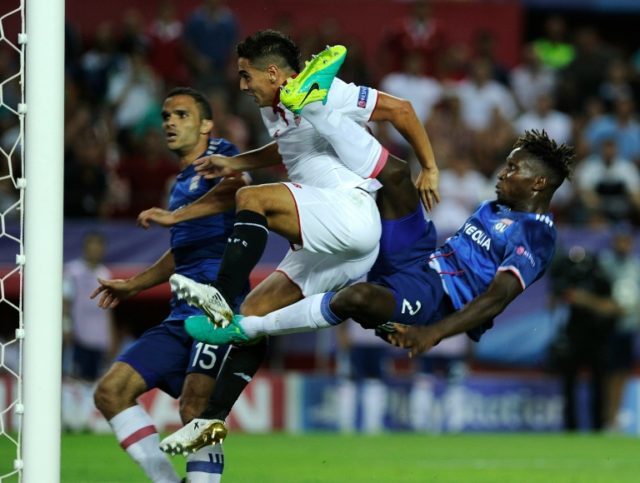 Sevilla's forward Wissam Ben Yedder (C) scores a goal beside Lyon's defender Yanga-Mbiwa a