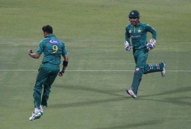 Pakistan's bowler Imad Wasim (L) celebrates with his teammate Sarfraz Ahmed after bolwing