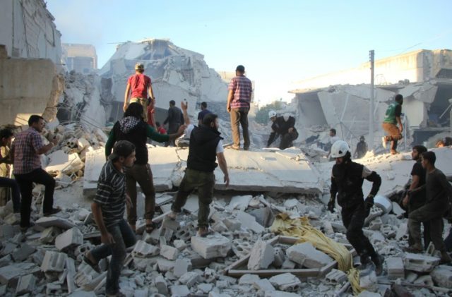Syrian men search for people under the rubble of destroyed buildings following a reported