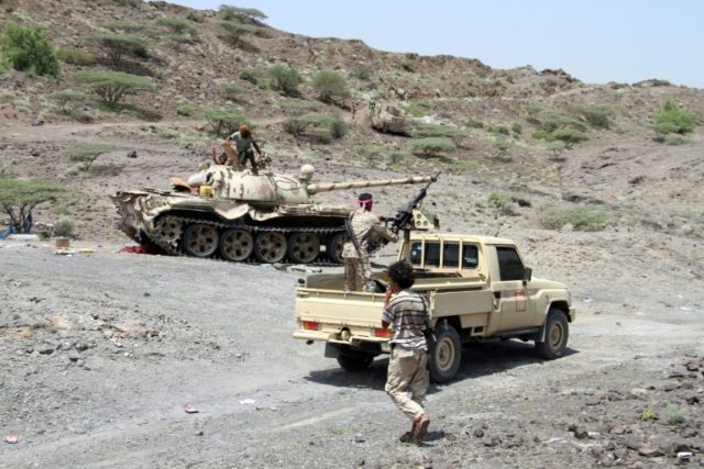 Yemeni pro-government forces fire toward Huthi rebels positioned in the hills of the Shari
