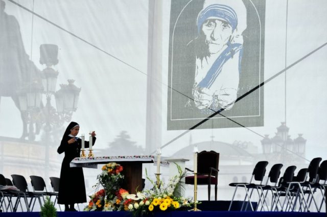 A nun lights a candle during the celebration for Mother Teresa's canonization in Skopje