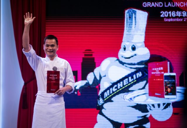 Master chef of T'ang Court, Justin Tan (L) waves on stage after the announcement of his th
