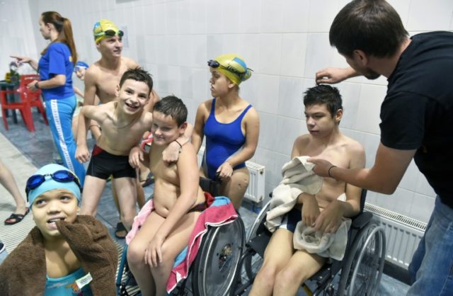 Disabled children rest after a training session in a swimming pool in Kiev