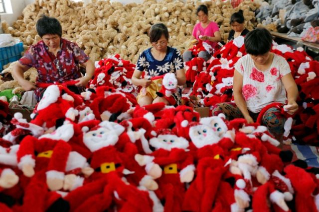 Chinese workers make Santa Claus dolls at a toy factory in Ganyu district in Lianyungang,