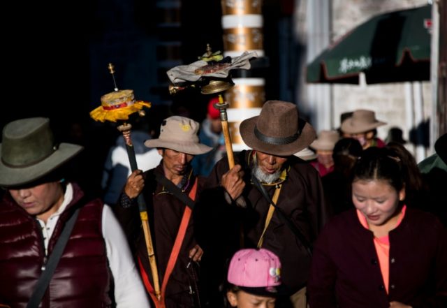 Pilgrims spin their prayer wheels outside the Jokhang Temple in the regional capital Lhasa